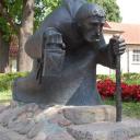 Beeld van een krom lopende monnik in Cēsis